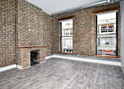 Thumbnail 7 of 8 - A room with a brick wall and a fireplace.