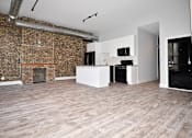 Thumbnail 2 of 8 - A room with a brick wall and wooden flooring.