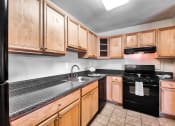 Thumbnail 4 of 40 - full kitchen with black appliances and granite counter tops and wood cabinets