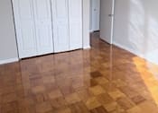 Thumbnail 40 of 40 - A room with a brown floor and white cupboards.