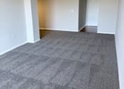 Thumbnail 2 of 40 - A family room with a carpeted floor and white walls.