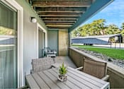 Thumbnail 100 of 111 - A wooden table with a potted plant on it sits on a patio.