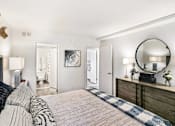 Thumbnail 102 of 111 - A bedroom with a bed, dresser, and mirror.