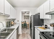 Thumbnail 104 of 111 - A kitchen with white cabinets and a black refrigerator.