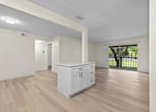 Thumbnail 12 of 111 - A white kitchen with wood flooring and a white fridge.