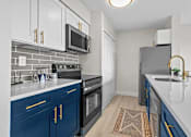 Thumbnail 2 of 111 - A kitchen with blue cabinets and a black oven.
