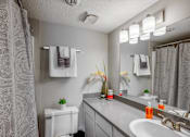 Thumbnail 32 of 111 - A bathroom with a white toilet, sink, and a mirror.