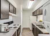 Thumbnail 40 of 111 - A kitchen with black cabinets and white appliances.