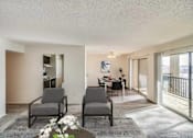 Thumbnail 41 of 111 - Two grey chairs are placed in a room with a table and a vase with white flowers.