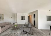Thumbnail 42 of 111 - A living room with a grey sofa, a coffee table, and a grey chair.