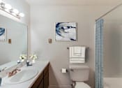 Thumbnail 43 of 111 - A bathroom with a toilet, sink, and mirror.