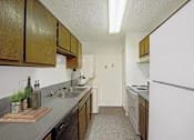 Thumbnail 47 of 111 - A kitchen with wooden cabinets and a white refrigerator.