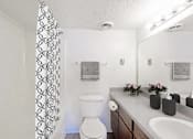 Thumbnail 48 of 111 - A white toilet sits in a bathroom next to a white sink.