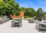Thumbnail 69 of 111 - A park with tables and chairs and a fence.
