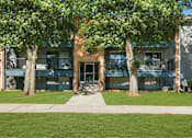 Thumbnail 70 of 111 - A building with a green lawn in front and trees on either side.