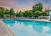 Thumbnail 76 of 111 - A large swimming pool with a sunset sky in the background.