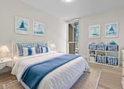 Thumbnail 7 of 111 - A bedroom with a white bed and blue accents.