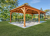 Thumbnail 85 of 111 - A wooden pavilion with a white base and a roof is surrounded by a grassy area.