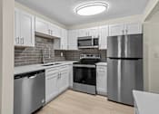 Thumbnail 9 of 111 - A kitchen with stainless steel appliances and white cabinets.
