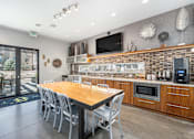 Thumbnail 12 of 26 - A modern kitchen with a wooden table and chairs.