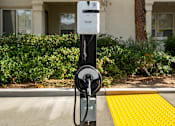 Thumbnail 21 of 22 - A parking meter is on the sidewalk in front of a building.