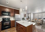 Thumbnail 1 of 26 - A modern kitchen with dark wood cabinets and a white island.