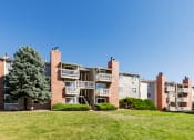 Thumbnail 29 of 29 - an exterior view of an apartment building with green grass and a tree