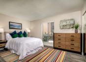 Thumbnail 5 of 28 - One Bedroom Apartments in Oceanside CA - Stone Arbor - Bedroom with Wood-Style Flooring, Mirrored Closets, and Large Window