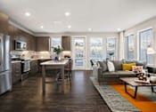 Thumbnail 20 of 26 - A modern kitchen with a dining table and a couch.