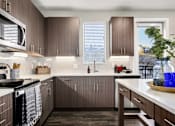 Thumbnail 18 of 26 - A kitchen with brown cabinets and a white counter.
