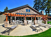 Thumbnail 16 of 24 - a patio with a pergola and lounge chairs on a sunny day