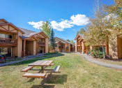 Thumbnail 10 of 18 - a picnic table in front of a group of buildings