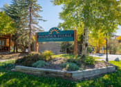Thumbnail 16 of 18 - a sign for mountain village apartments in front of trees