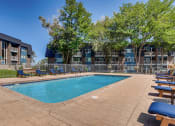 Thumbnail 15 of 19 - a swimming pool with chaise lounge chairs and trees in the background