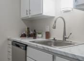 Thumbnail 5 of 19 - a kitchen with white cabinets and a stainless steel sink