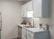 Thumbnail 6 of 19 - a kitchen with white cabinets and a stainless steel sink