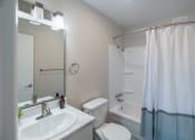 Thumbnail 7 of 19 - a bathroom with a white sink and toilet next to a white bathtub with a shower curtain