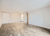 Thumbnail 27 of 28 - an empty living room with wood flooring and white walls