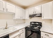Thumbnail 10 of 28 - a kitchen with white cabinets and black appliances