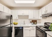 Thumbnail 6 of 28 - a kitchen with white cabinets and black appliances