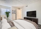 Thumbnail 8 of 28 - a bedroom with a large bed in front of a flatscreen tv