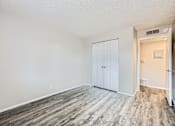 Thumbnail 22 of 28 - an empty living room with white walls and wood flooring