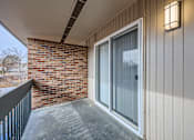 Thumbnail 20 of 28 - the front door of a condo with a brick wall