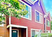 Thumbnail 1 of 3 - A house with a blue door and a red siding.