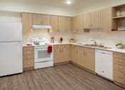 Thumbnail 17 of 36 - A kitchen with white appliances and wooden cabinets.