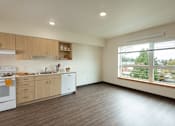 Thumbnail 19 of 36 - A kitchen with wooden floors and white appliances.