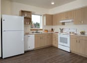 Thumbnail 2 of 36 - A kitchen with white appliances and wooden cabinets.
