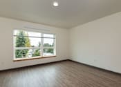 Thumbnail 20 of 36 - A room with a large window and wooden flooring.