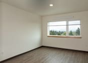 Thumbnail 21 of 36 - A room with a window overlooking a forest.