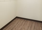 Thumbnail 23 of 36 - A white wall with a wooden floor and a white shelf.